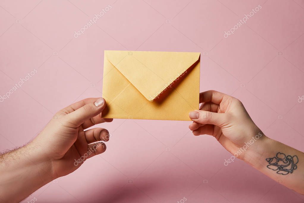 Partial view of woman with tattoo and man holding yellow envelope on pink background