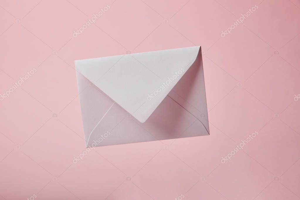 White and empty envelope isolated on pink with copy space