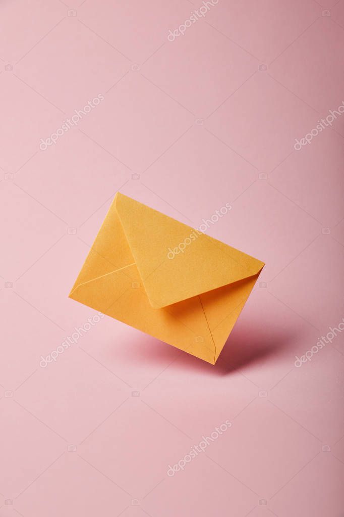 Yellow and colorful envelope on pink background with copy space