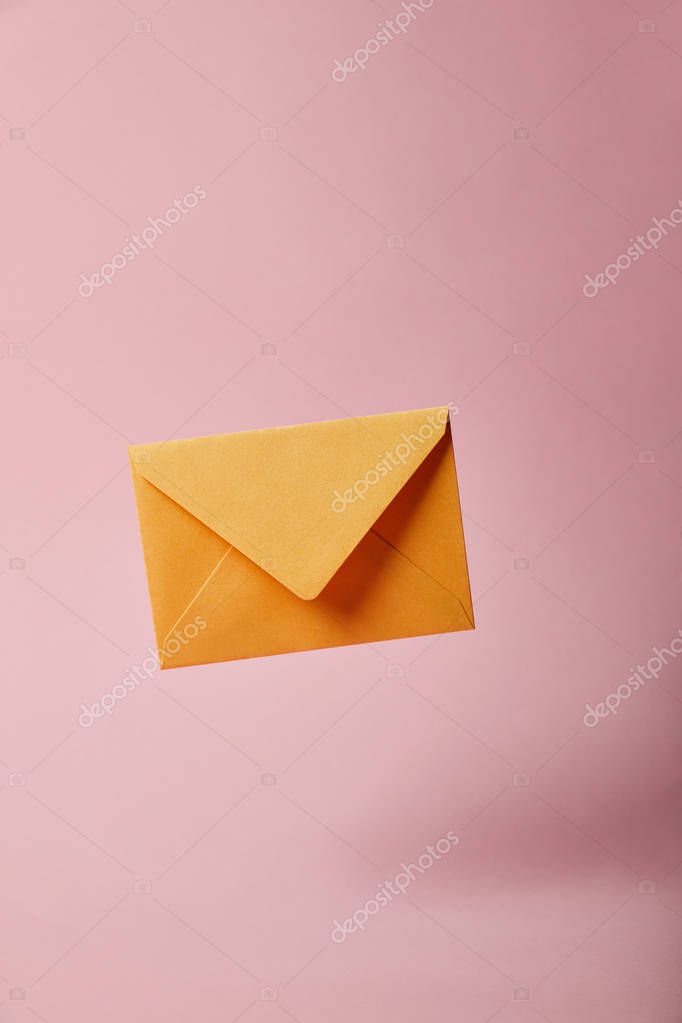 Yellow and bright envelope on pink background with copy space