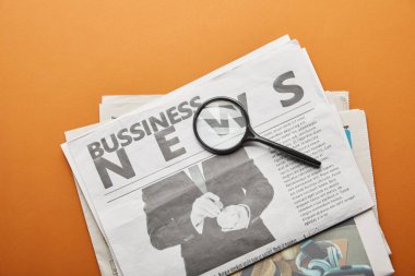 Büyüteç portakal yakınındaki iş gazetesi 