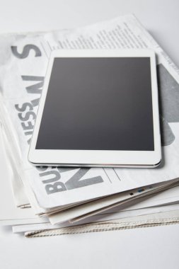 digital tablet with blank screen on business newspapers on white  clipart