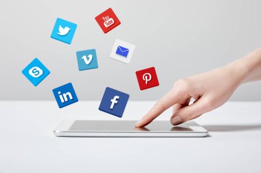 farklı simgeler yakınındaki dijital tablet gri kullanan kadın görünümünü kırpılmış 