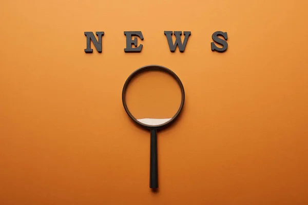 Draufsicht Auf Nachrichtenschriftzug Der Nähe Von Lupe Auf Orange — Stockfoto
