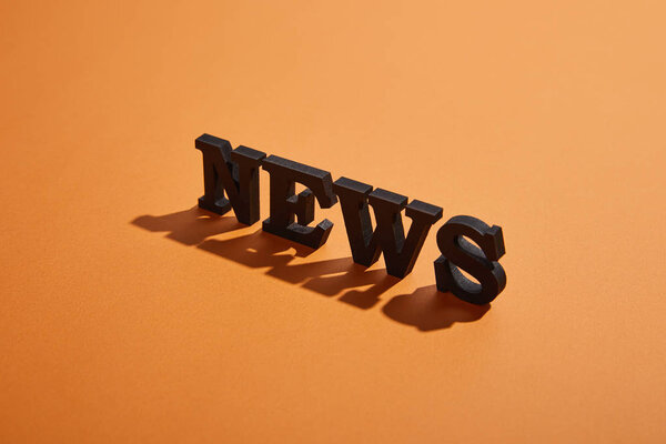 news lettering with copy space and shadows on orange 
