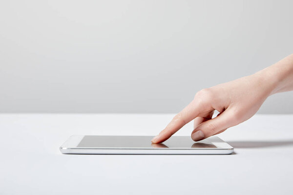 обрезанный вид женщины с помощью цифрового планшета на белом
 