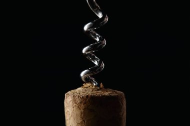 Close up view of wooden cork and steel corkscrew isolated on black clipart