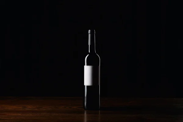 Butelka Wina Pustą Etykietę Powierzchni Drewnianych Czarnym Tle — Zdjęcie stockowe