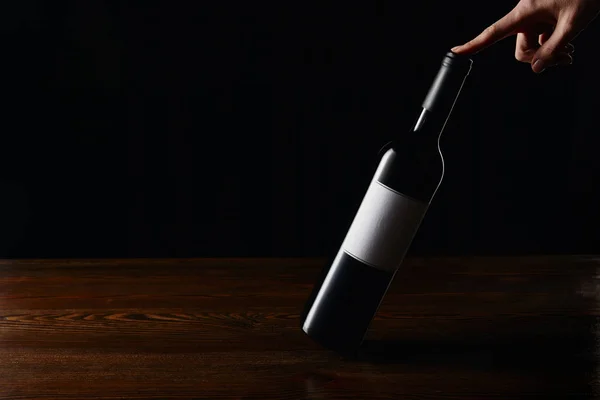 Częściowy Widok Kobiety Dotykając Butelki Wina Powierzchni Drewnianych Czarnym Tle — Zdjęcie stockowe