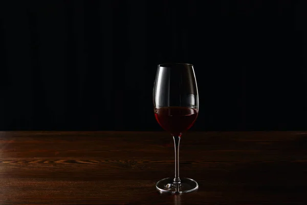 Glas Rotwein Auf Hölzerner Oberfläche Isoliert Auf Schwarz — Stockfoto