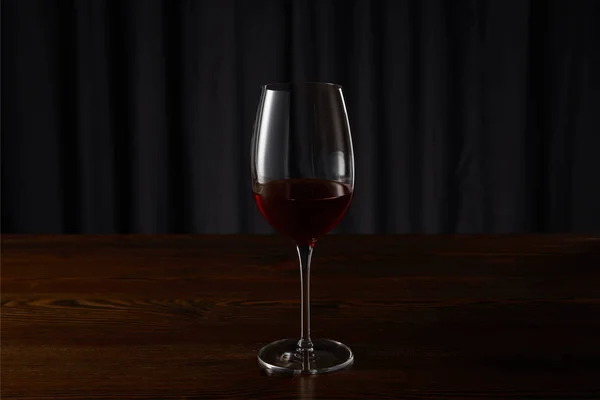 Glas Mit Rotwein Auf Hölzerner Oberfläche Auf Dunkel — Stockfoto