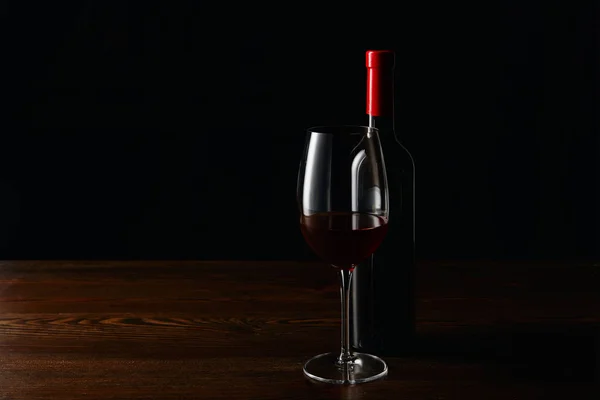 Flasche Und Glas Rotwein Auf Holzoberfläche Isoliert Auf Schwarz — Stockfoto