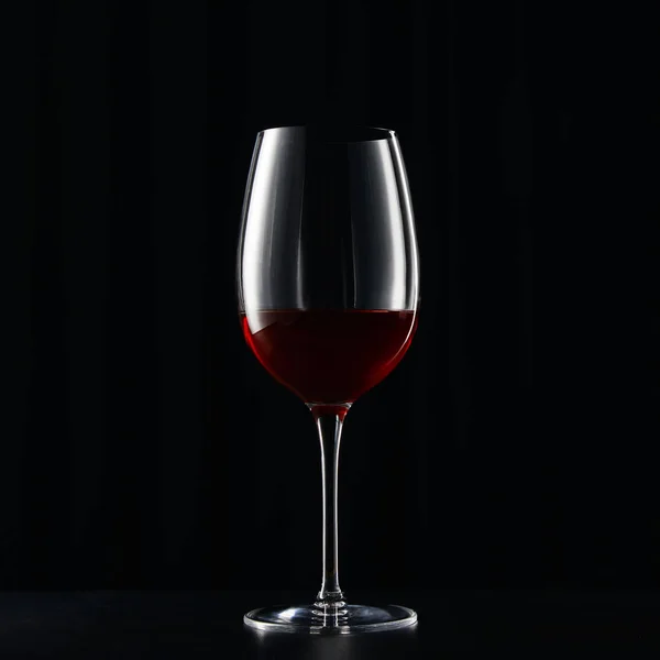 Ποτήρι Κόκκινου Κρασιού Στην Σκοτεινή Επιφάνεια Που Απομονώνονται Μαύρο — Φωτογραφία Αρχείου
