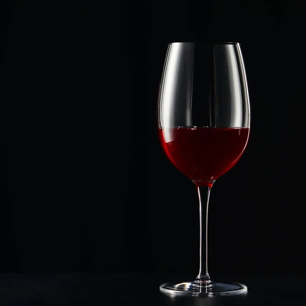Ποτήρι Κρασιού Κόκκινο Κρασί Στην Σκοτεινή Επιφάνεια Που Απομονώνονται Μαύρο — Φωτογραφία Αρχείου