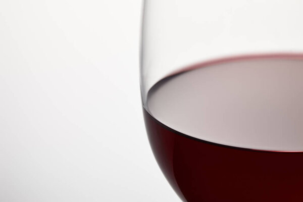 Wine glass of burgundy red wine on white