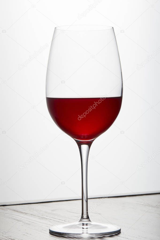 Glass of red wine on dark surface on white