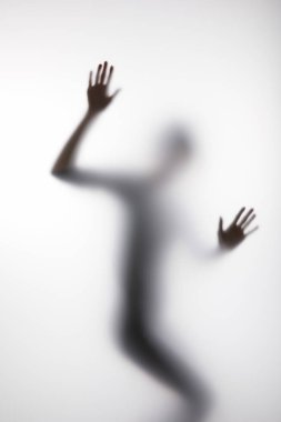 Blurry silhouette of person touching glass with hands clipart