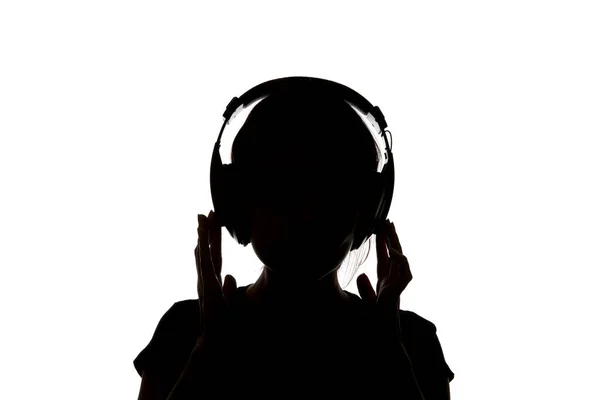 ホワイトに分離されたヘッドフォンで音楽を聴いているヘッドフォンで女の子のシルエット — ストック写真