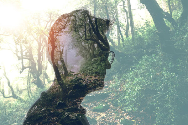 Double exposure of man in glasses and green forest