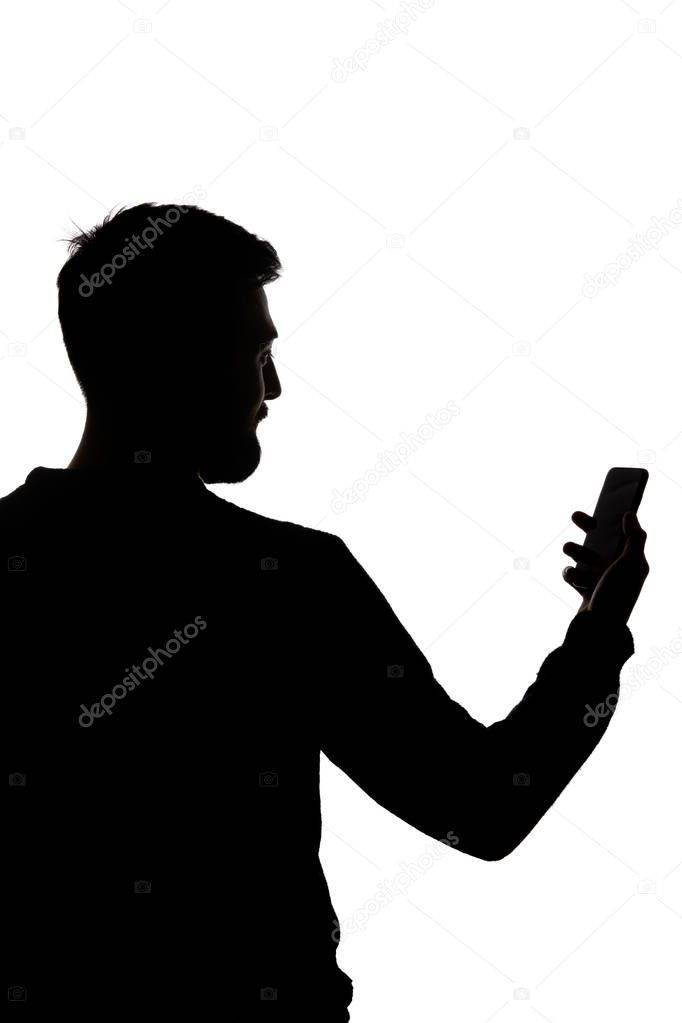 Silhouette of man holding smartphone with blank screen isolated on white