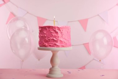 pasta stand yakın hava balonları ve dekorasyon mum yanan ile pembe lezzetli doğum günü pastası 