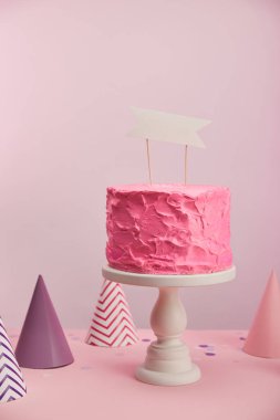 lezzetli ve tatlı doğum günü pastası parti kapaklar pembe üzerinde yakınındaki boş kartı ile 