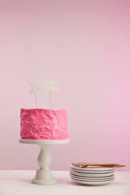 lezzetli ve tatlı pasta kek stand beyaz daireler yakınındaki boş kartı ve pembe üzerinde altın çatal ile 