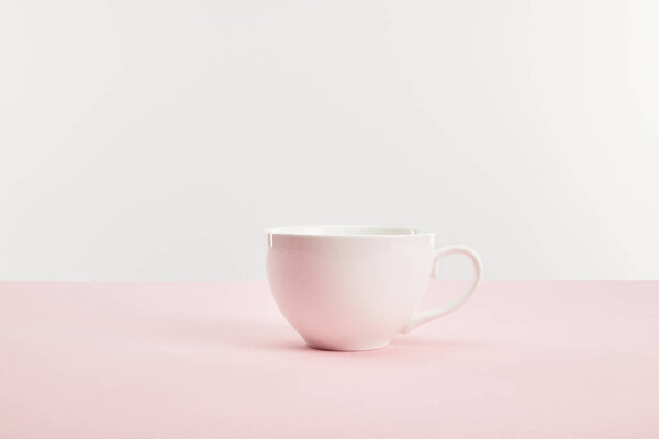 white cup with drink on pink surface isolated on grey 