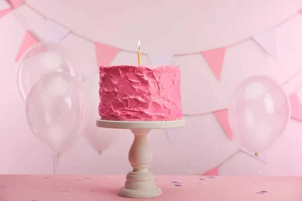 気球と装飾に近いケーキ スタンドにキャンドルを燃焼とピンク美味しい誕生日ケーキ — ストック写真