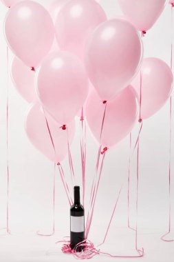 pembe hava balonları ile şarap şişesi üzerinde beyaz izole