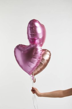 Kısmi beyaz izole kalp şeklinde pembe hava balonları tutan kız görünümünü