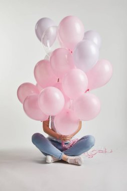 oturma ve yüz beyaz üzerine pembe hava Balonlu kapsayan kız
