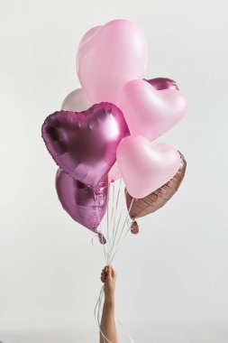 kırpılmış üzerinde beyaz izole kalp şeklinde pembe hava balonları tutan kız görünümünü