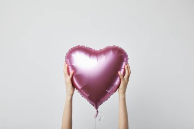 beyaz izole kalp şeklinde kırpılmış görünümü tutan kız pembe hava balonu