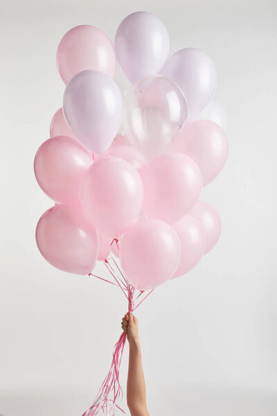 обрезанный вид девушки, держащей розовые воздушные шары изолированы на белом
