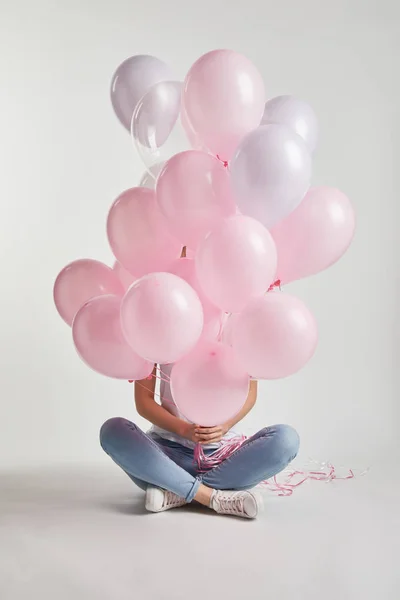 Девушка Сидит Покрывает Лицо Розовыми Воздушными Шарами Белом — стоковое фото