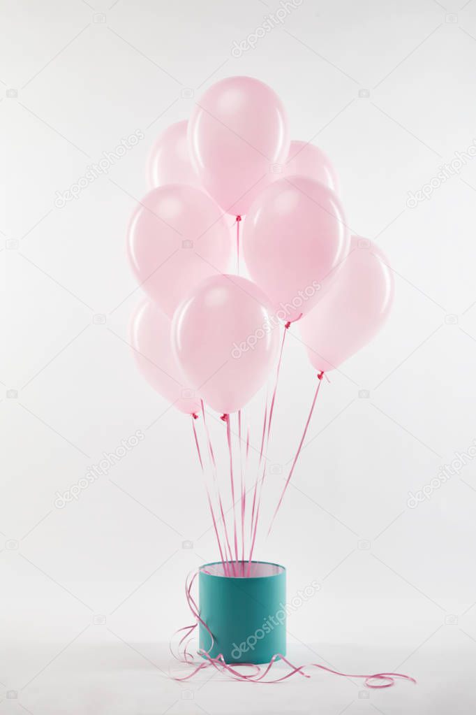 bundle of pink balloons with turquoise gift box on white
