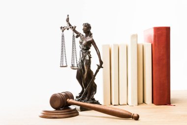 figurine with scales of justice, brown gavel and books on wooden table isolated on white clipart
