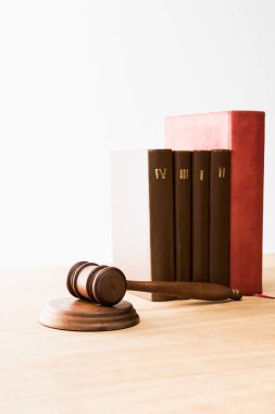 brown gavel near row of red and brown books on wooden table isolated on white clipart