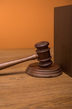 ahşap masa üzerinde turuncu izole kahverengi kitap deri kapağı ve tokmak yakın çekim
