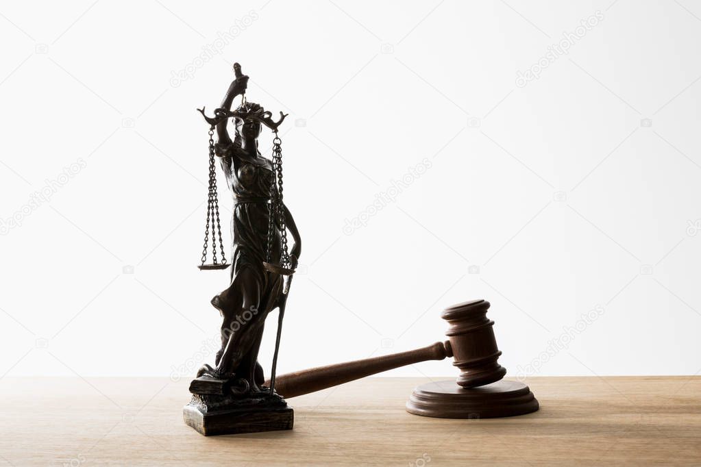 bronze statuette with scales of justice near wooden gavel on table isolated on white