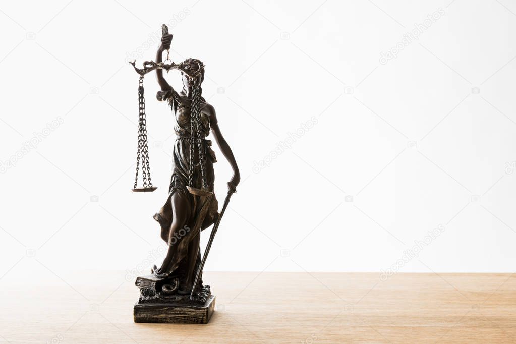 bronze statuette with scales of justice on wooden surface isolated on white with copy space