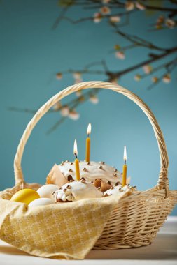 easter cakes with chicken eggs and napkin in wicker basket on turquoise clipart