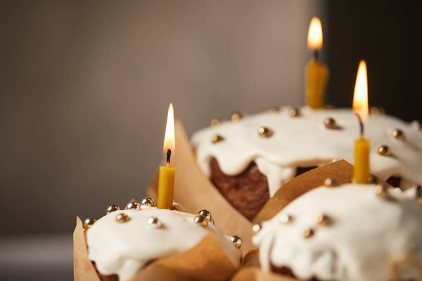 selective focus of traditional easter cakes with sprinkles and burning candles