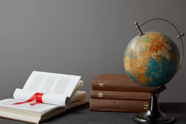 Gri üzerinde izole kırmızı şerit ile Globe, kitaplar ve diploma