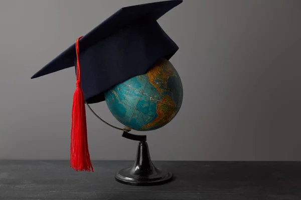 Academic Cap Red Tassel Globe Dark Surface — Stock Photo, Image