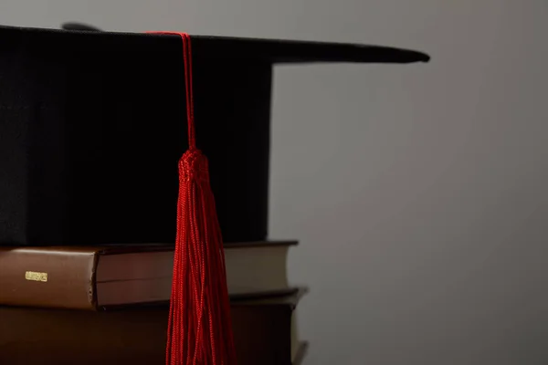 Libri Marroni Berretto Accademico Con Nappa Rossa Isolata Grigio — Foto Stock