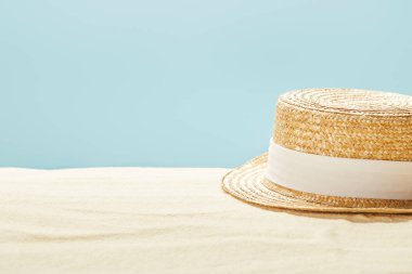 mavi üzerinde izole yaz aylarında kumlu plajda saman şapka seçici odak