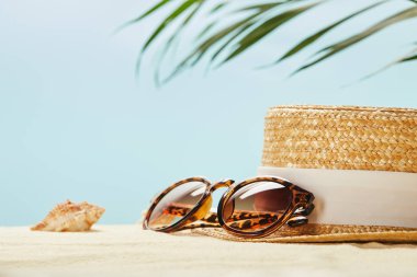 mavi üzerinde izole yaz aylarında saman şapka ve deniz kabuğu yakın güneş gözlüğü seçici odak