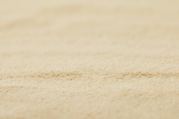 selective focus of textured sandy surface on beach in summertime